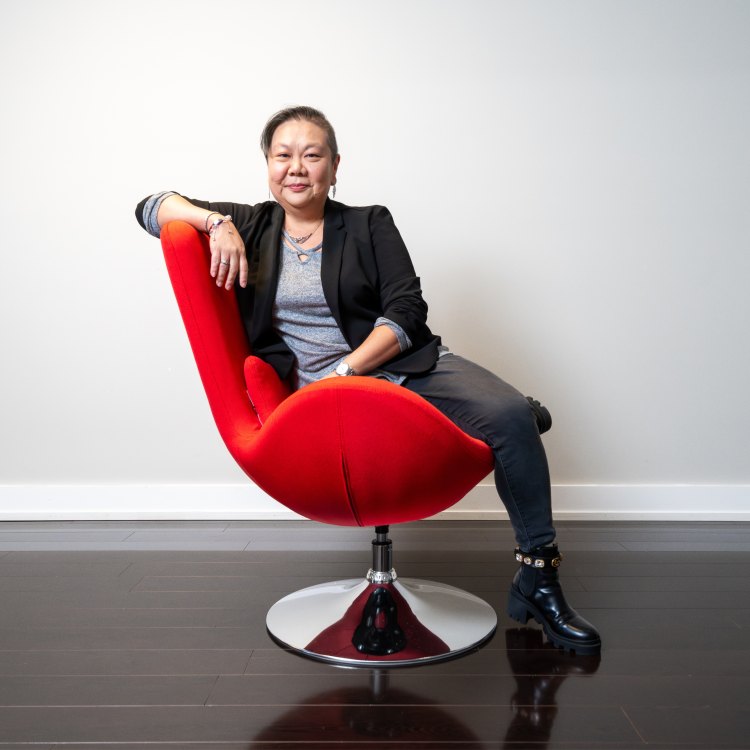 Nancy Chu, seated in a red chair